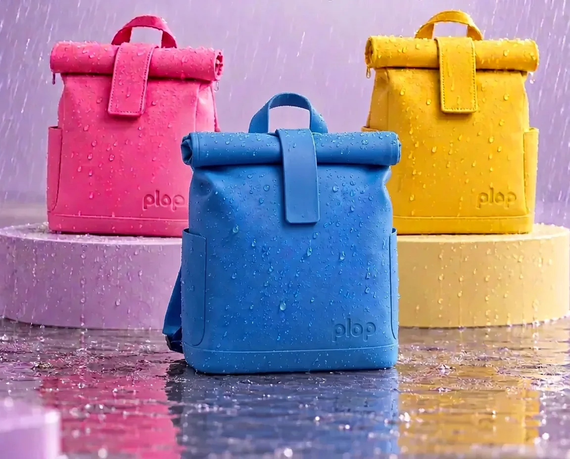 Pig pink, sea blue and bee yellow plop backpacks on pastel plinths under falling rain